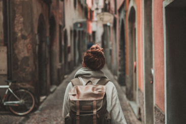 woman walking on street surrounded by buildings