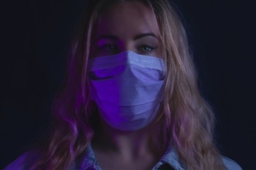 woman in purple denim jacket with white mask