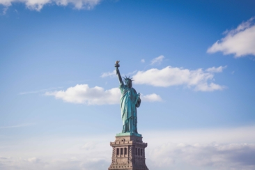 Statue of Liberty, New York under white and blue cloudy skies