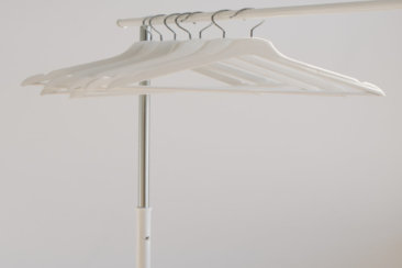 white clothes hangers hanging on rack