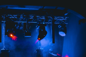 man in black jacket playing guitar on stage