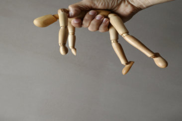 person holding brown wooden mannequin