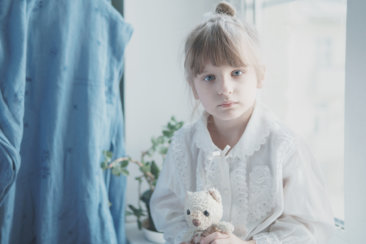 girl in white dress holding white bear plush toy