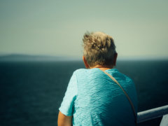 man in blue shirt sitting on boat during daytime