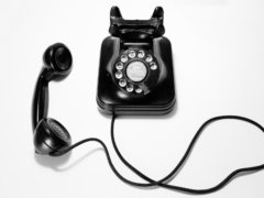 black rotary dial phone on white surface