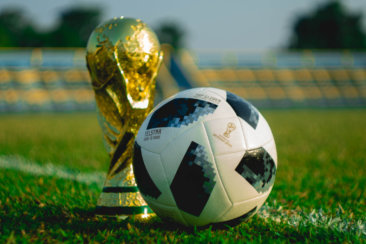 soccer ball beside trophy on soccer field