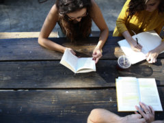 woman reading book while sitting on chair