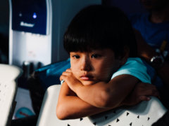 boy leaning on white chair