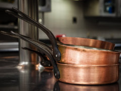 three brass colored cooking pans