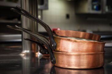 three brass colored cooking pans