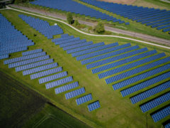 aerial photography of grass field with blue solar panels