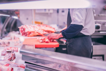 man slicing raw meat