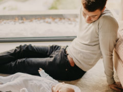 man in gray sweater lying on floor beside man in black shirt