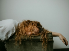 woman in white shirt lying on black textile