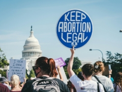 a group of people holding up signs in front of the capitol building