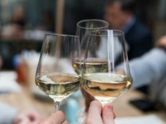 three people having a toast using three clear crystal wine glasses