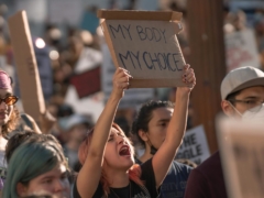 A Woman Protesting Holding a Banner